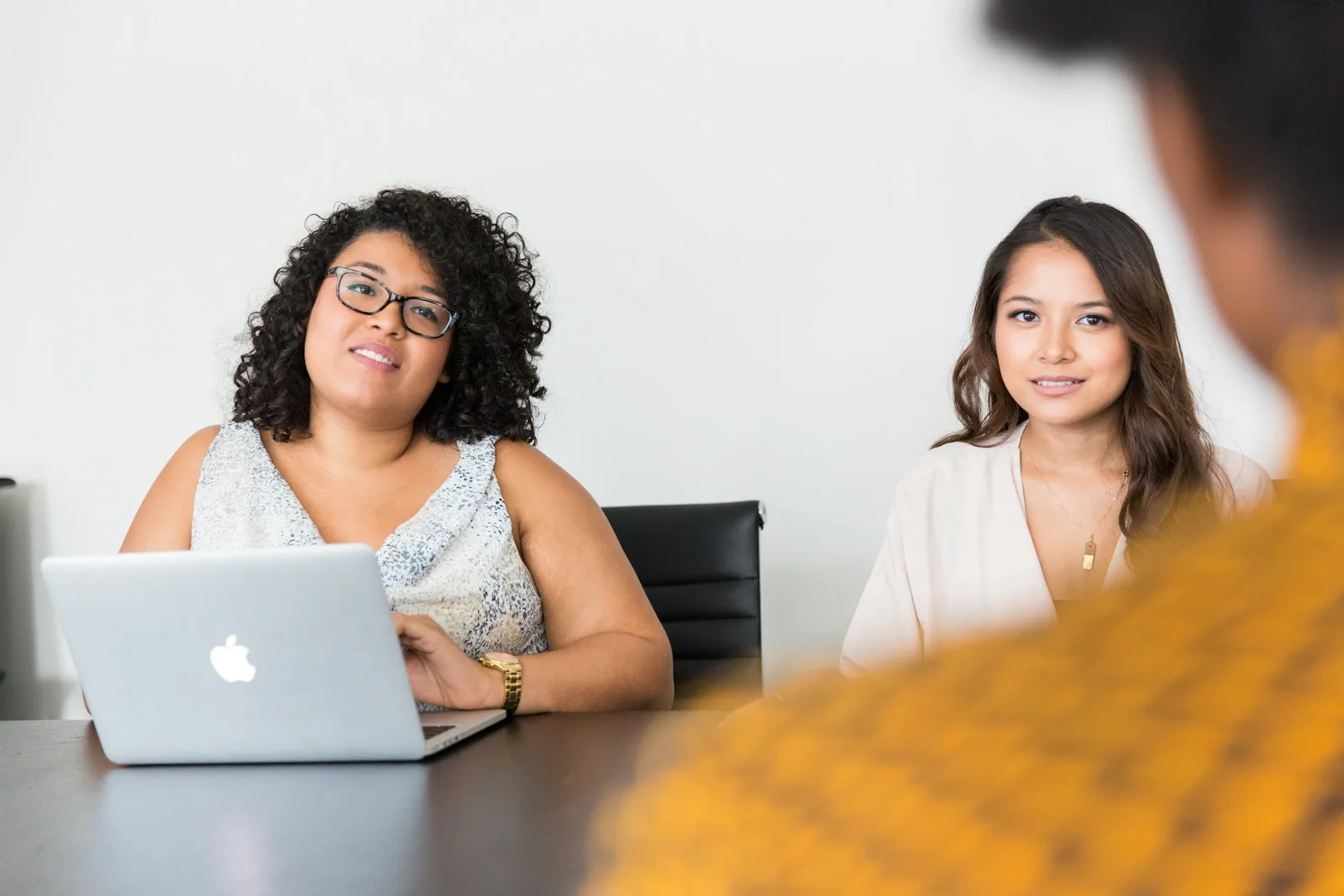 Two coworkers reviewing a laptop screen together during a hiring discussion, representing how a business should evaluate an AI agent developer before hiring one